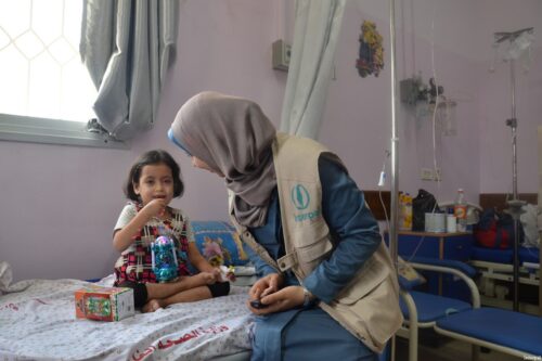 An Interpal aid worker seen with a Palestinian child in hospital
