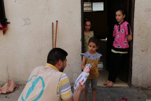 Interpal staff distribute aid to Palestinian refugee child