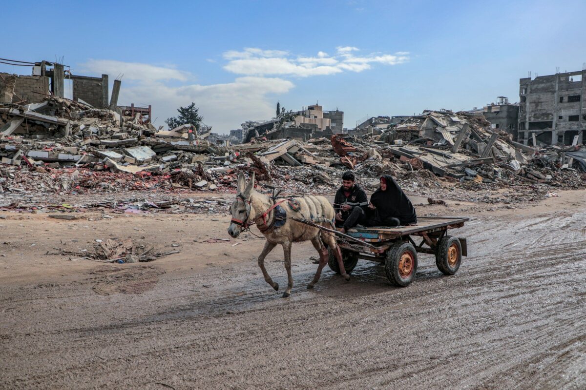 A young man and his mother drive a donkey cart through the streets of Jabalia camp, Gaza on June 10, 2025 [Mohammed Ibrahim / Unsplash]